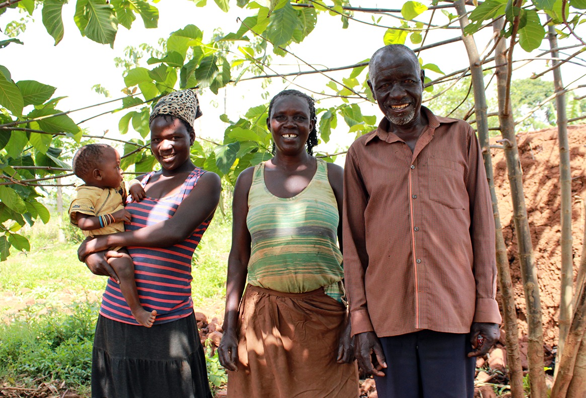 Zedrack and his family standing together in their thriving Forest Garden, highlighting the power of education and agroforestry.